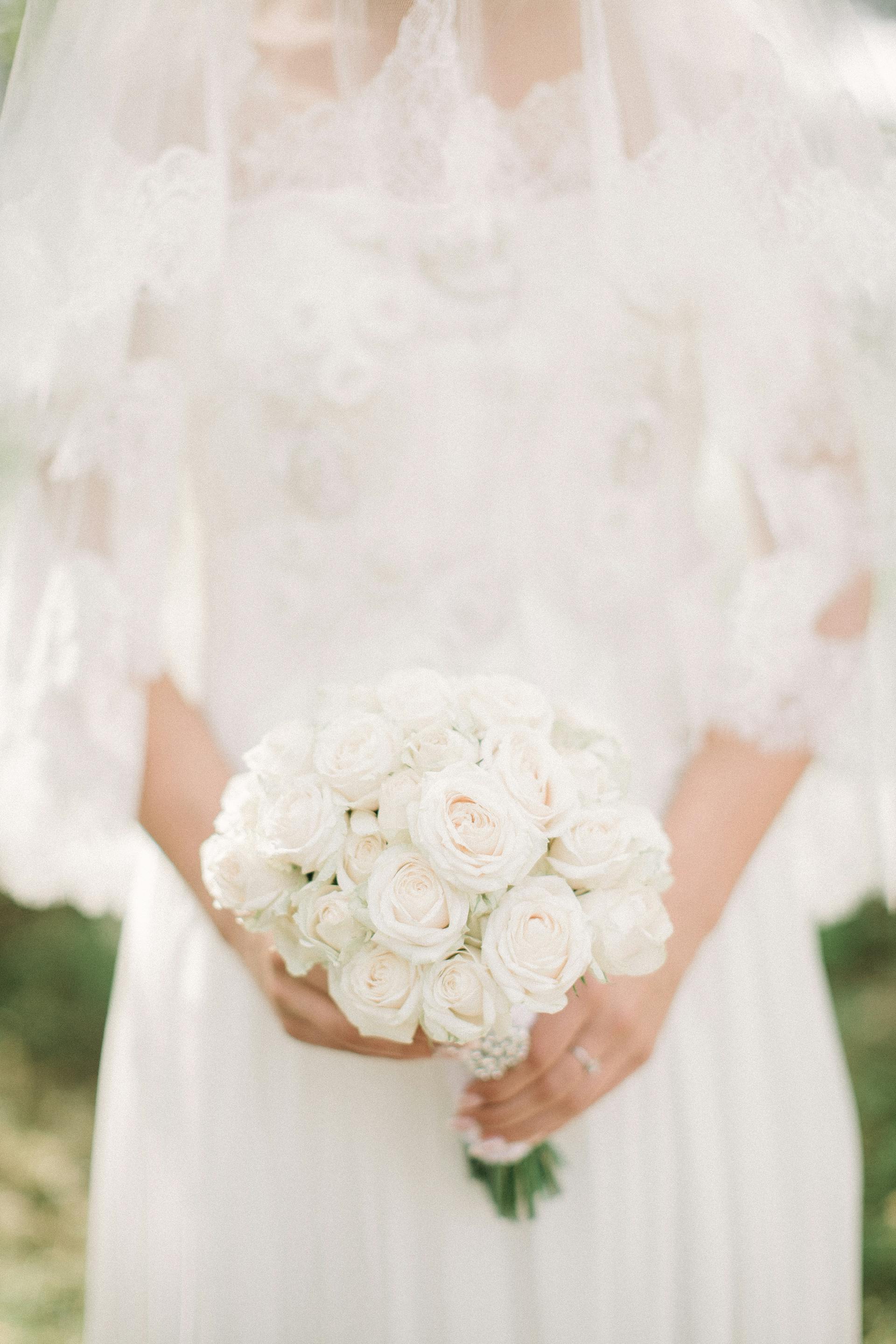 Une mariée avec un bouquet de roses blanches