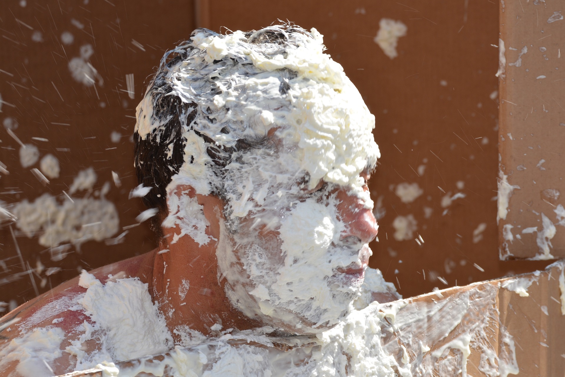 De la crème éclaboussée sur le visage d'un homme