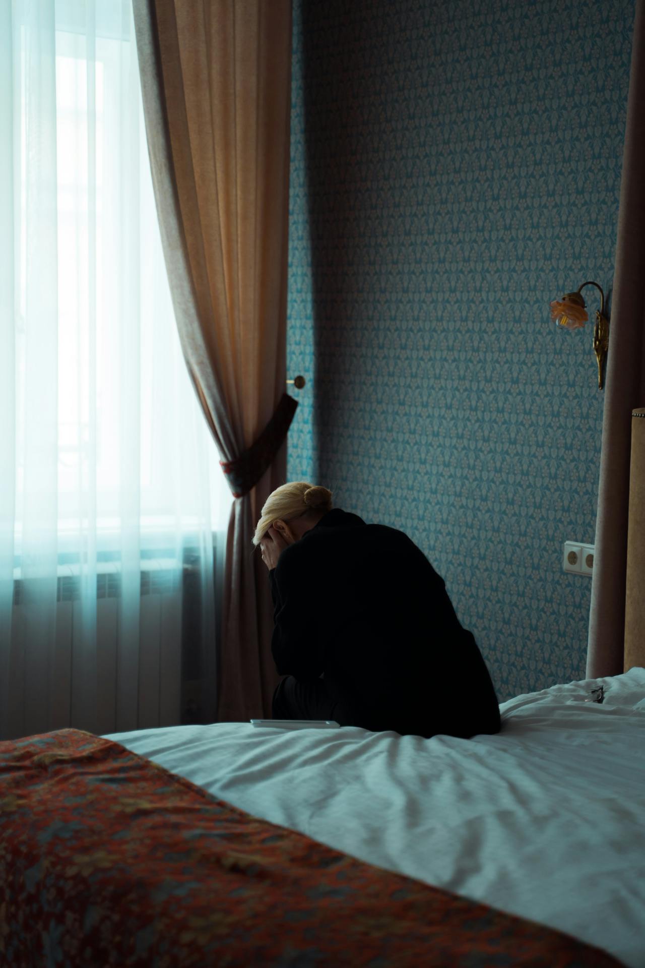 Une femme déprimée assise sur son lit