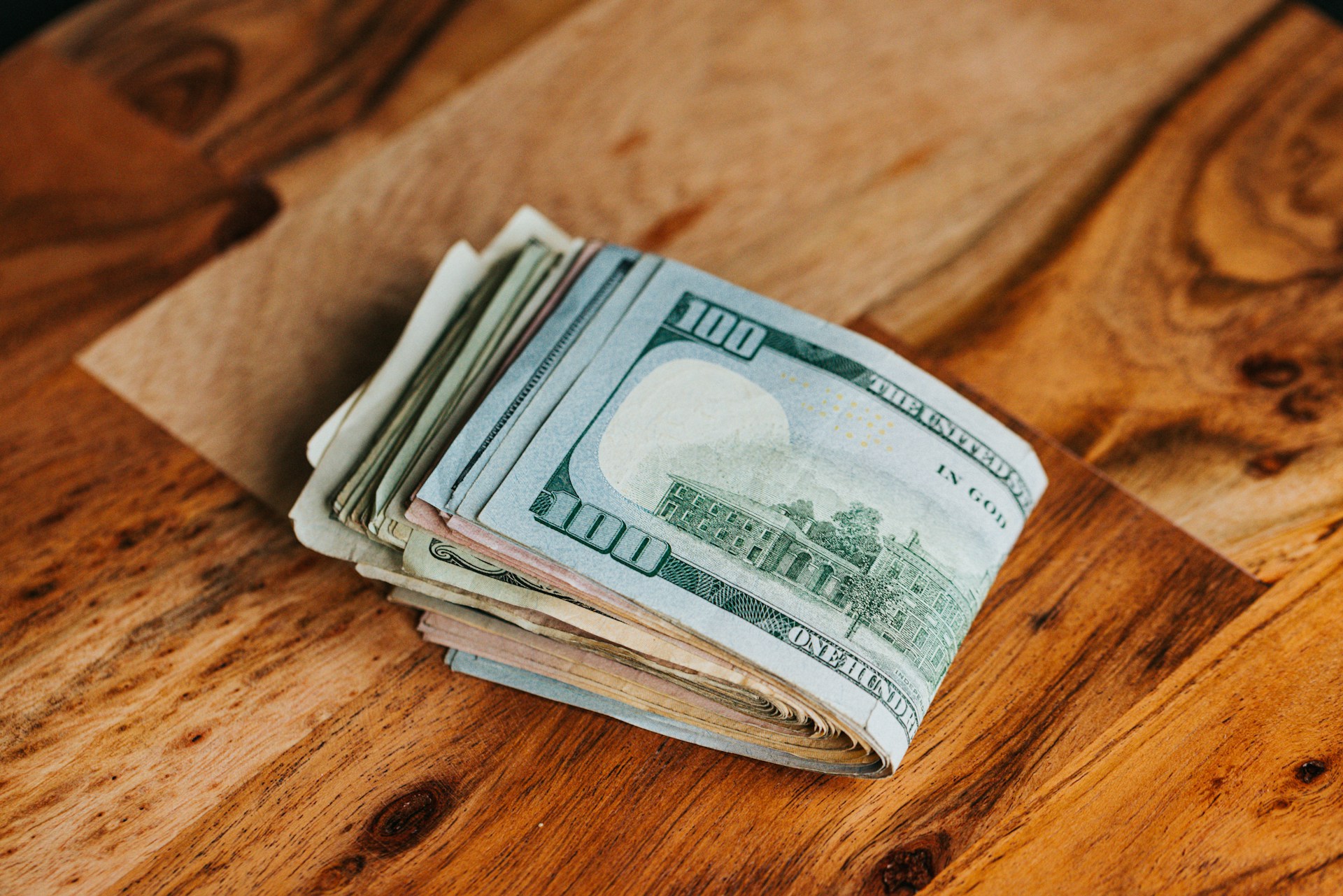 Des billets de dollars posés sur une table en bois