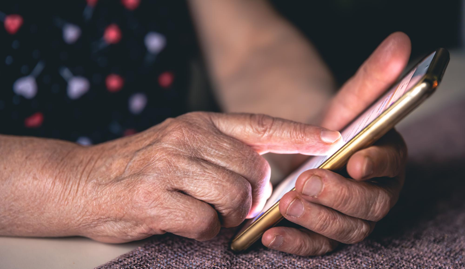 Gros plan d'une femme âgée tenant un téléphone